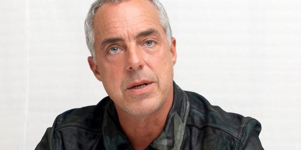 titus-welliver-in-a-black-coat-in-front-of-a-while-background-1.jpg