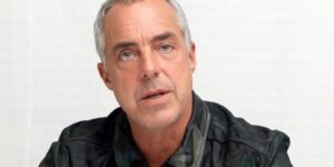 titus-welliver-in-a-black-coat-in-front-of-a-while-background-1.jpg