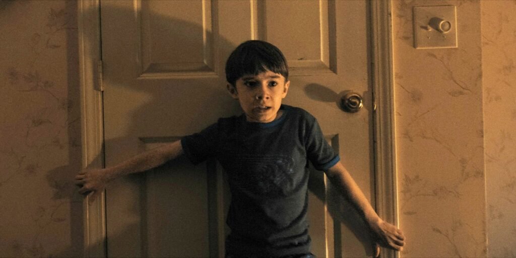 alex-standing-in-front-of-a-door-clutching-the-frame-with-a-terrified-expression-in-weapons.jpg