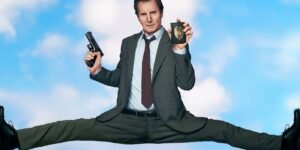 liam-neeson-in-a-deep-split-holding-a-gun-and-a-badge-in-the-new-naked-gun.jpg