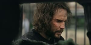 taylor-kitsch-s-ben-looking-beat-up-next-to-a-blown-up-car-in-the-terminal-list-dark-wolf.jpg
